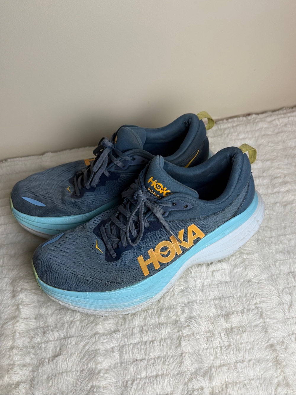 Hoka Navy Running Shoes with Yellow/Orange Logo and Light Blue Midsole